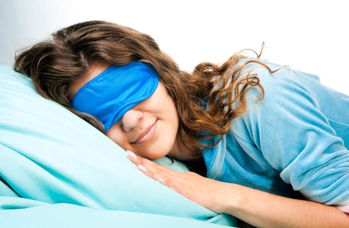 young woman sleeping blue sleep mask